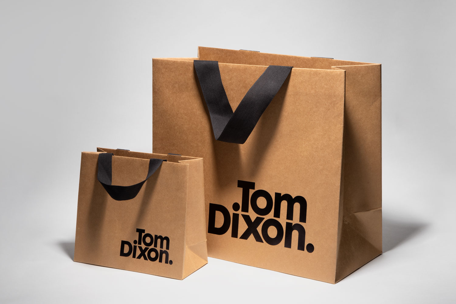 Fully recyclable custom luxury carrier bag with paper ribbon handle manufactured by Progress Packaging