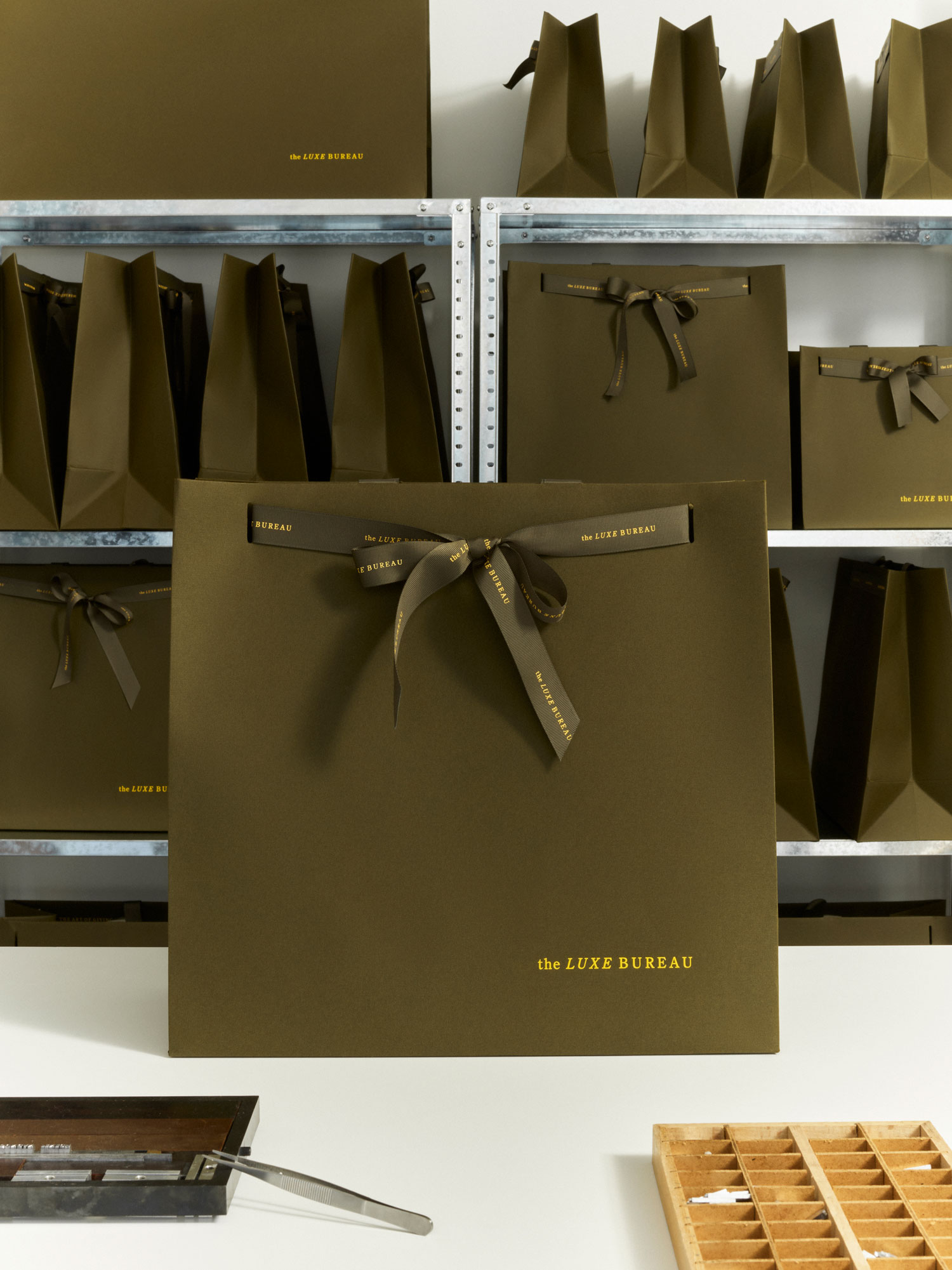 Luxury retail carrier bags, Progress Packaging Production, bespoke bubble print ribbon handle, sustainable materials, gold foil branding